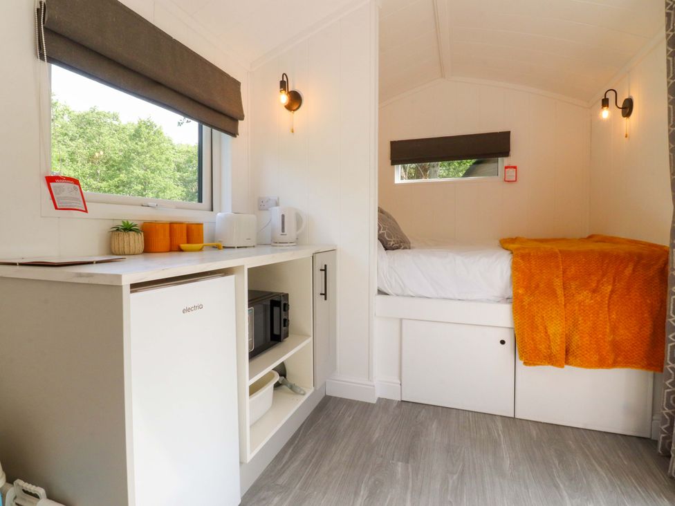 A kitchenette and a bed in a studio at Shepherds Hut 2