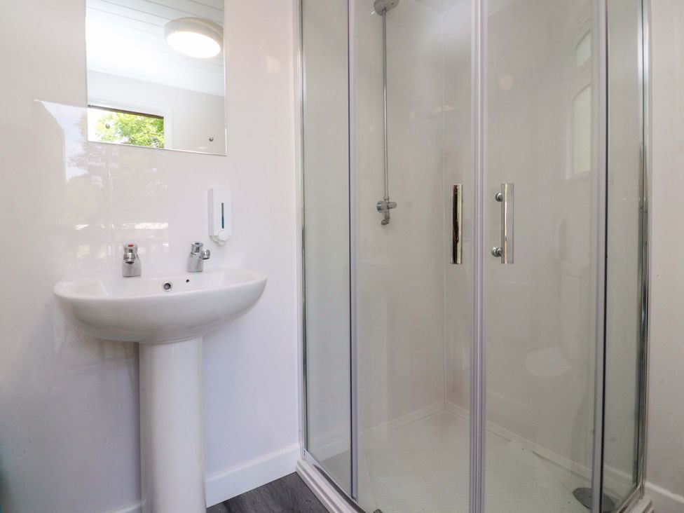 A bathroom with a sink and shower area at Shepherds Hut 2