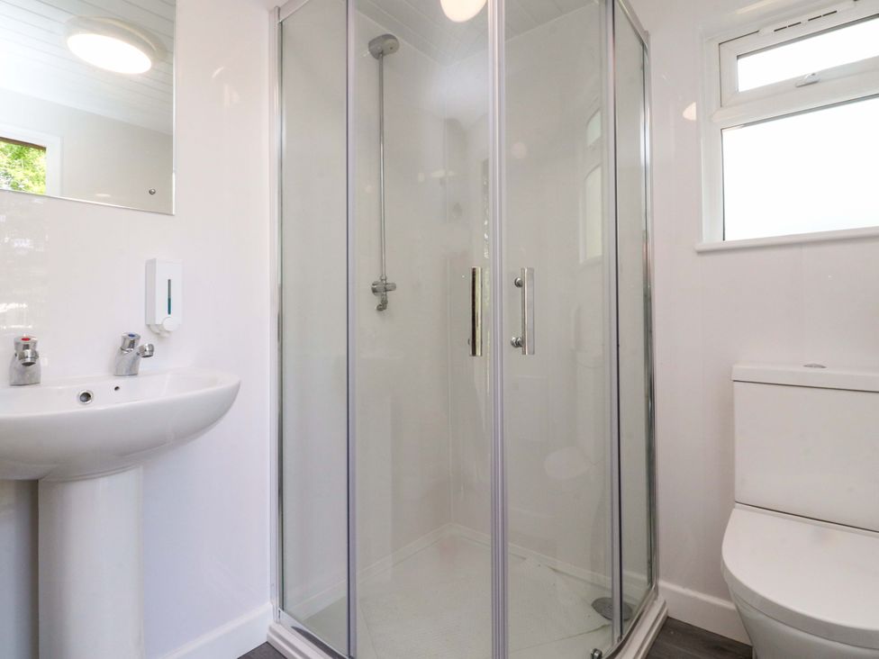 A bathroom with a sink, shower, and toilet at Shepherds Hut 2