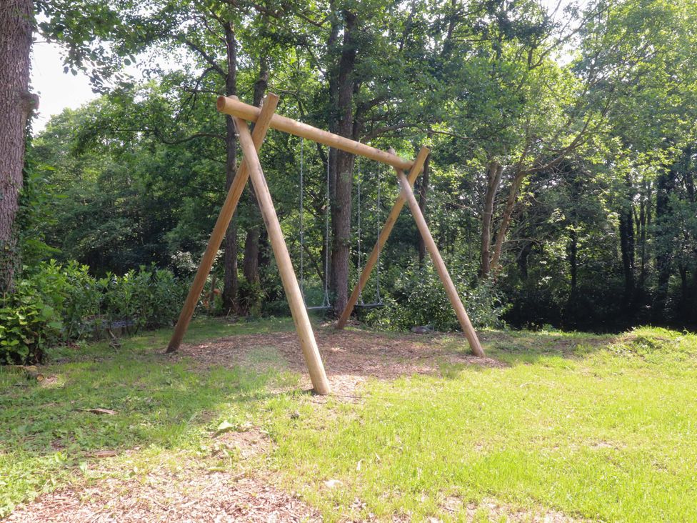 A swing set located in a green area with trees