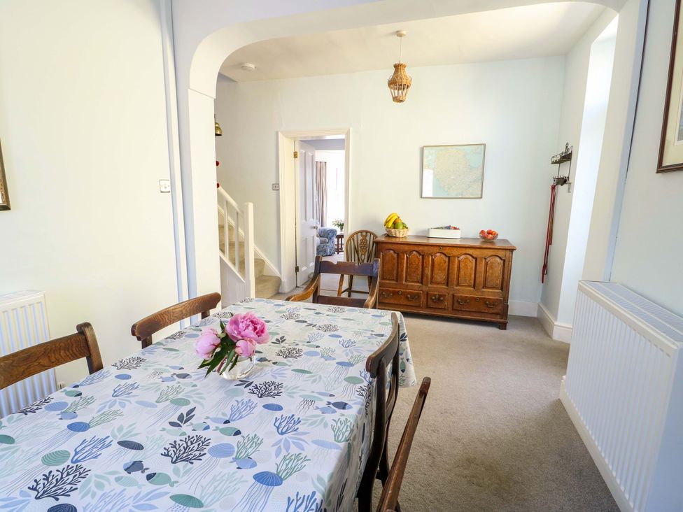 A dining room with a table and chairs at Trwst Y Don in Rhosneigr