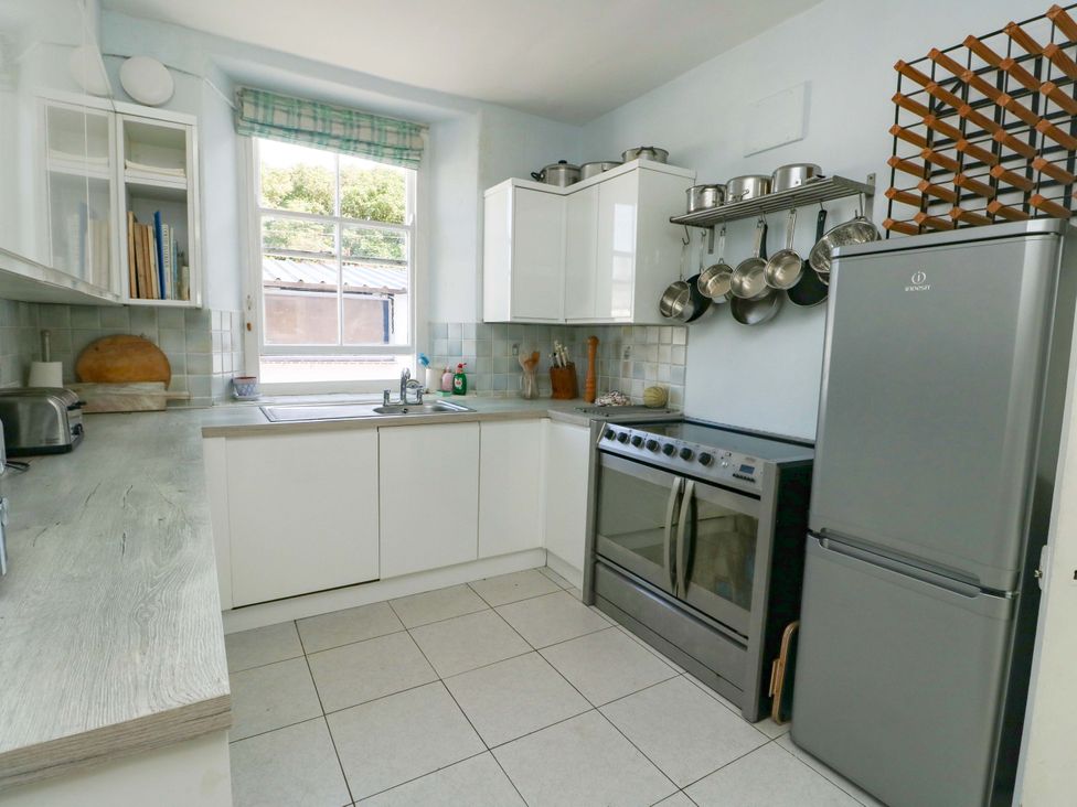 A kitchen with sink, oven, and refrigerator at Trwst Y Don in Rhosneigr