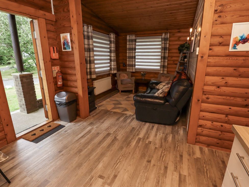 A living room with a sofa and chairs at Farnes Lodge in Longframlington