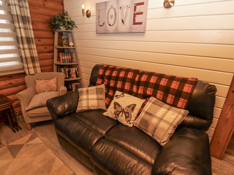A living room with a sofa and armchair at Farnes Lodge in Longframlington
