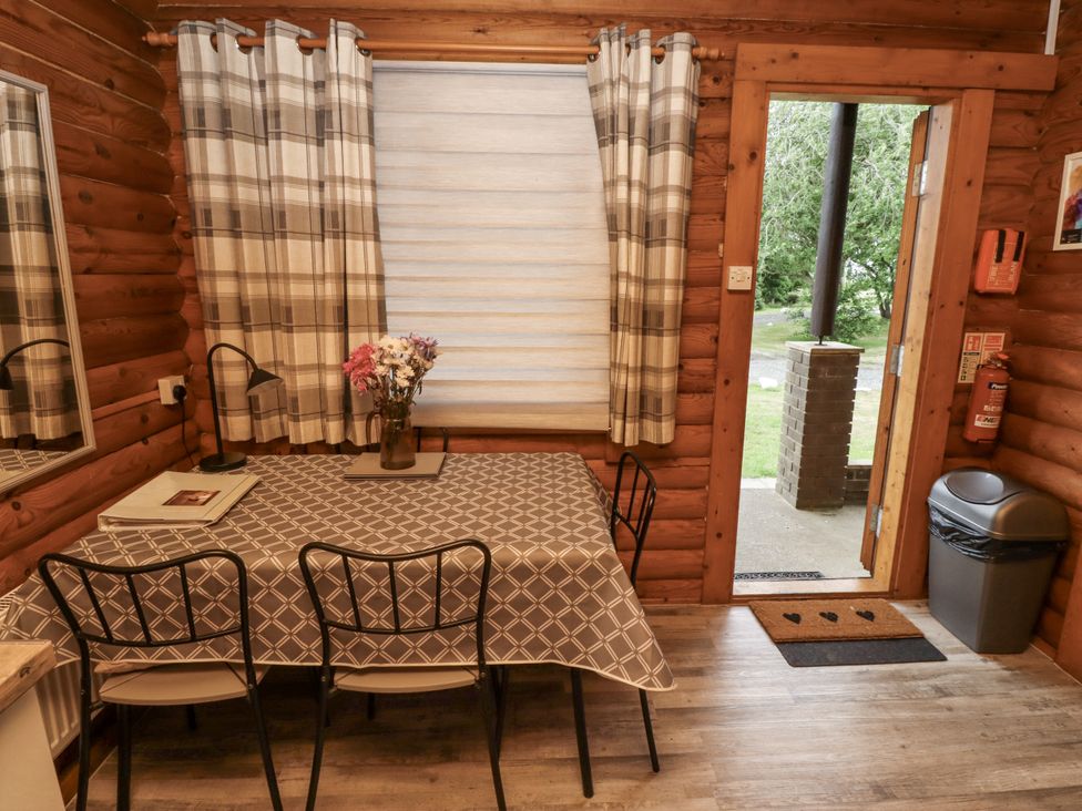 A dining room with a table and chairs at Farnes Lodge in Longframlington