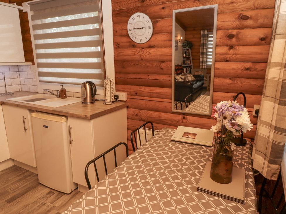 A kitchen with a table and chairs at Farnes Lodge Longframlington