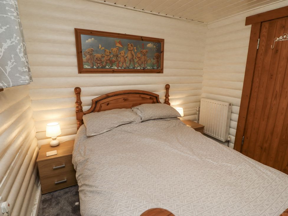 A bedroom with a bed and nightstand at Farnes Lodge Longframlington