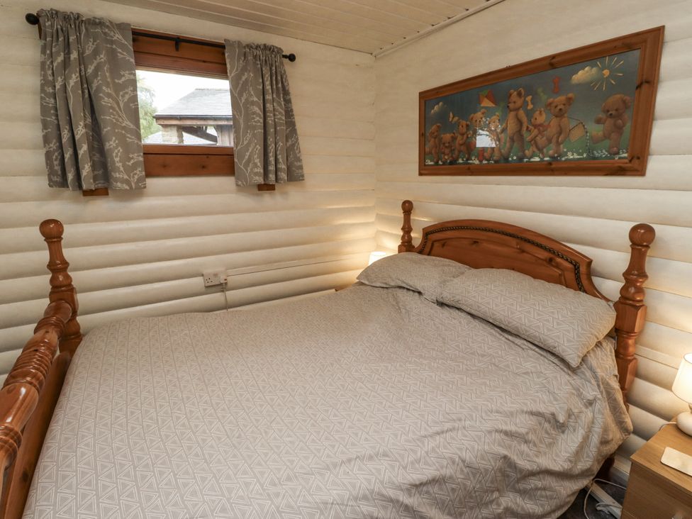 A bedroom with a bed and curtains at Farnes Lodge in Longframlington