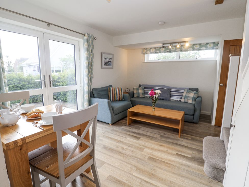 A living room with a dining table and sofa at The Annex next to St Johns in Southwold