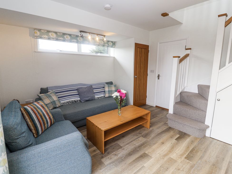 A living room with a sofa and coffee table at The Annex next to St Johns Southwold