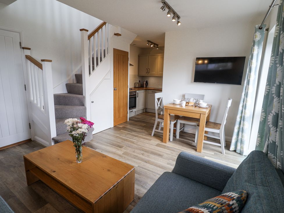 A living room with a dining area and kitchen at The Annex next to St Johns Southwold