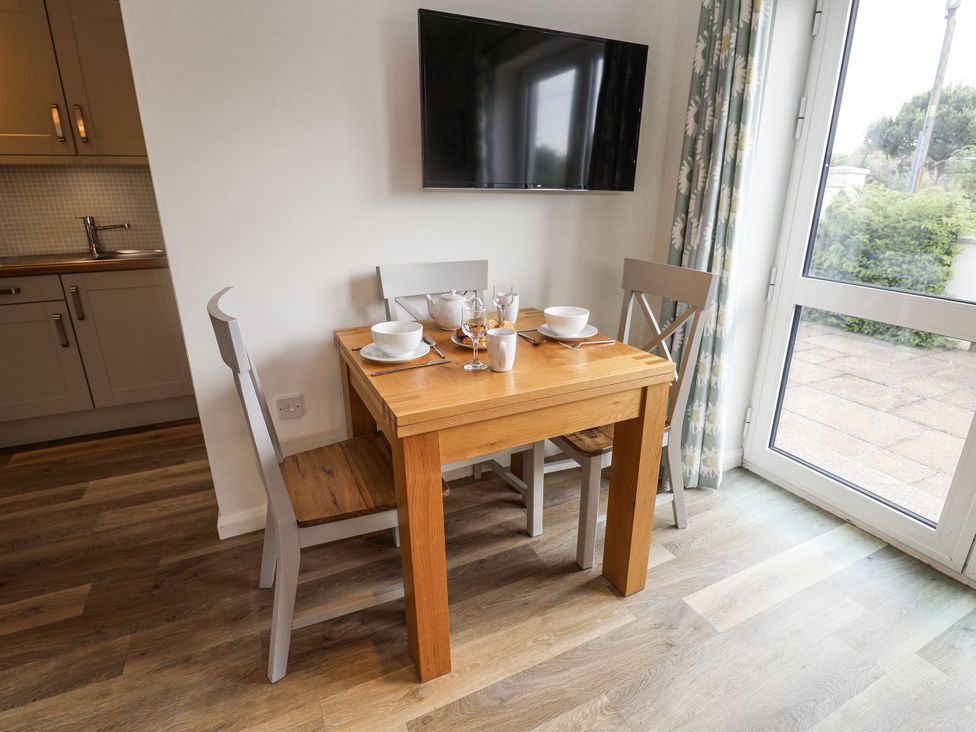 A dining area with a table and chairs at The Annex next to St Johns in Southwold