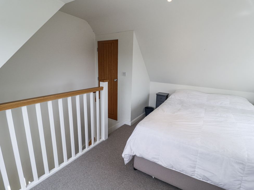 A bedroom with a bed and nightstand at The Annex next to St Johns in Southwold