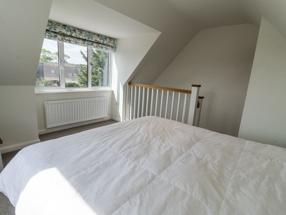 A bedroom with a bed and window at The Annex next to St Johns Southwold