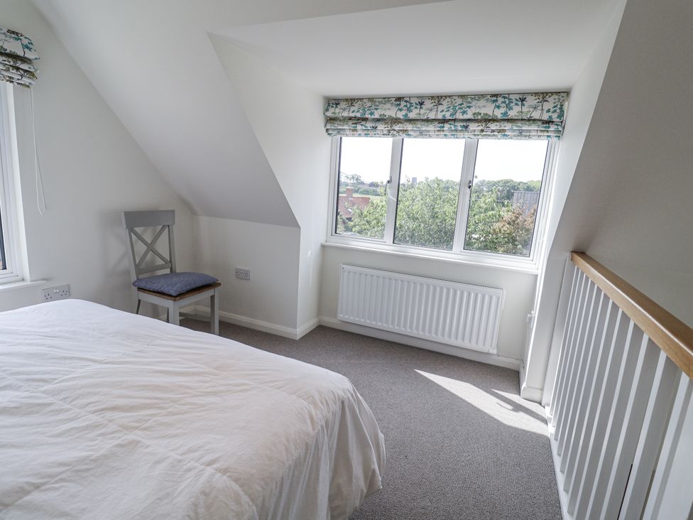 A bedroom with a bed and chair at The Annex next to St Johns Southwold