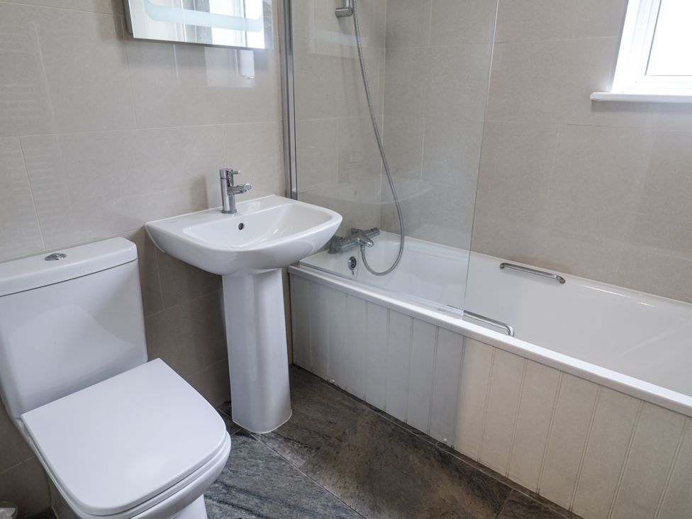 A bathroom with a sink, toilet, and bathtub at The Annex next to St Johns Southwold