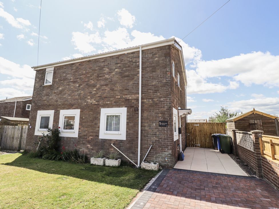 A house with grass and paving stones at Seahorse Cottage in Chathill
