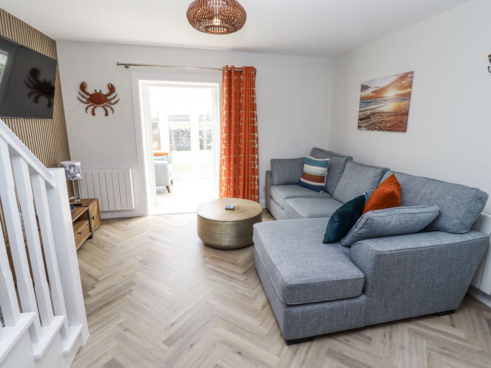 A living room with a sofa and coffee table at Seahorse Cottage in Chathill