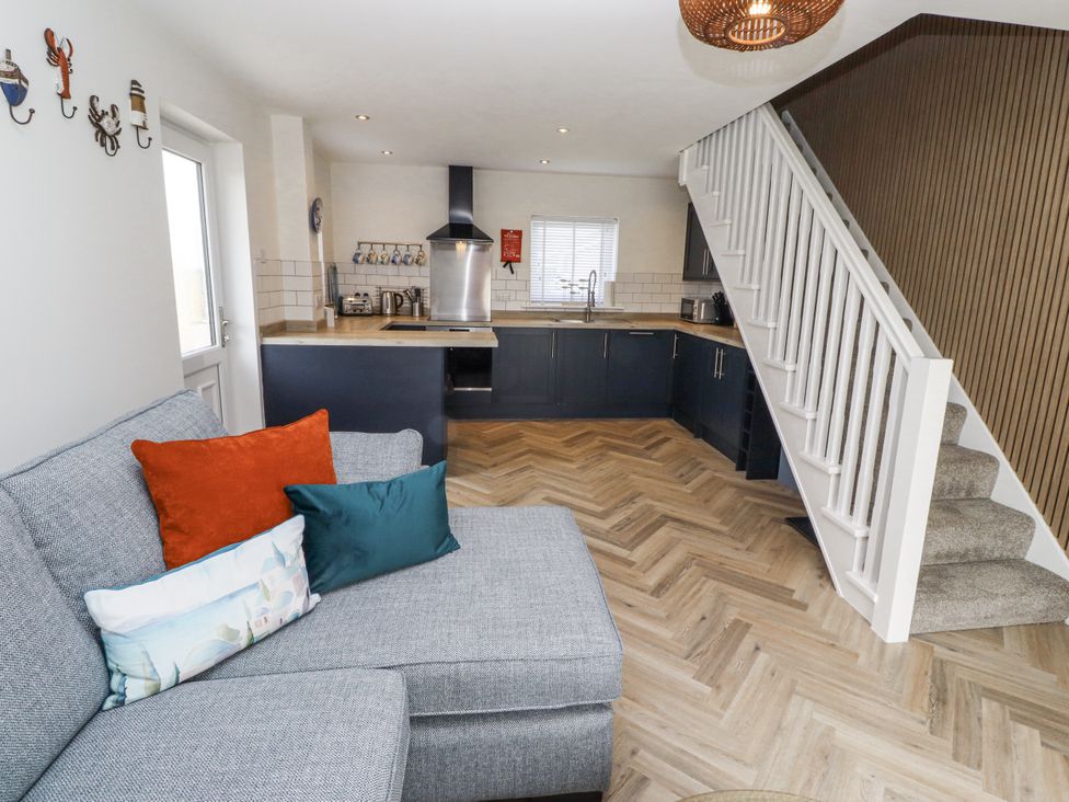 A kitchen with a sofa and staircase at Seahorse Cottage in Chathill