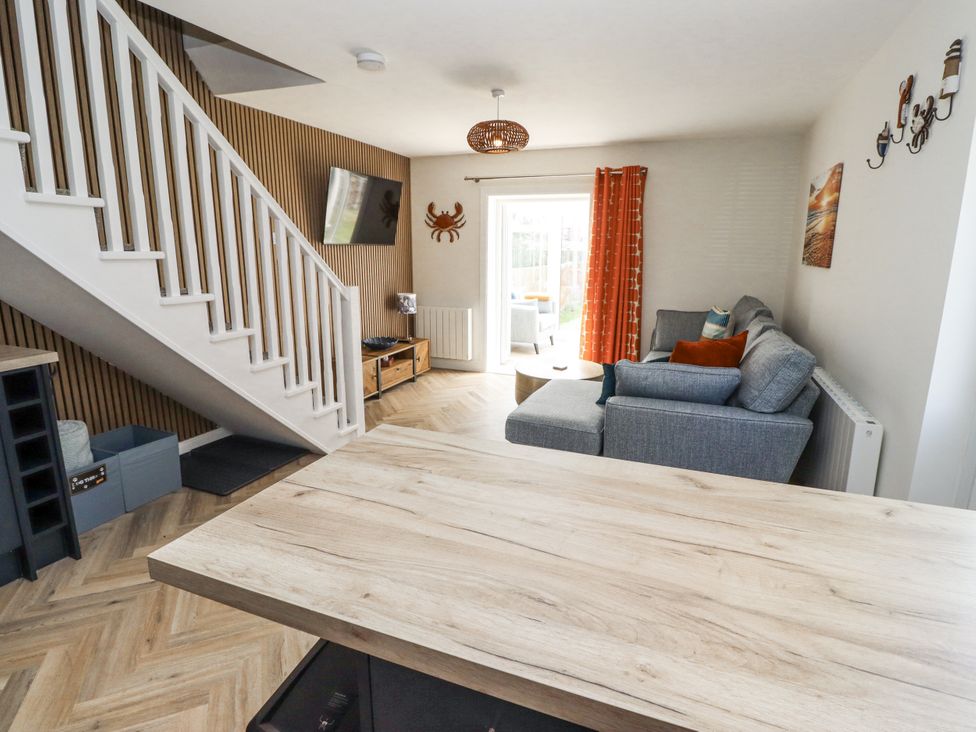 A living room with a sofa and television at Seahorse Cottage in Chathill