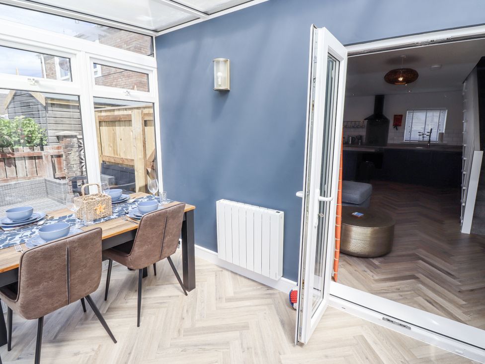 A dining room with a table and chairs at Seahorse Cottage in Chathill