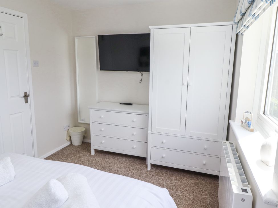 A bedroom with a television and wardrobe at Seahorse Cottage in Chathill