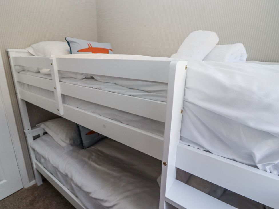 A bunk bed with pillows and towels at Seahorse Cottage in Chathill