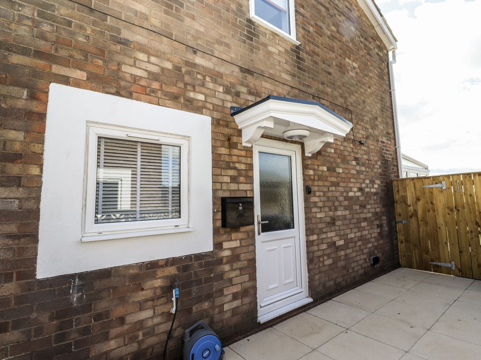 An entrance with a door and a window at Seahorse Cottage in Chathill