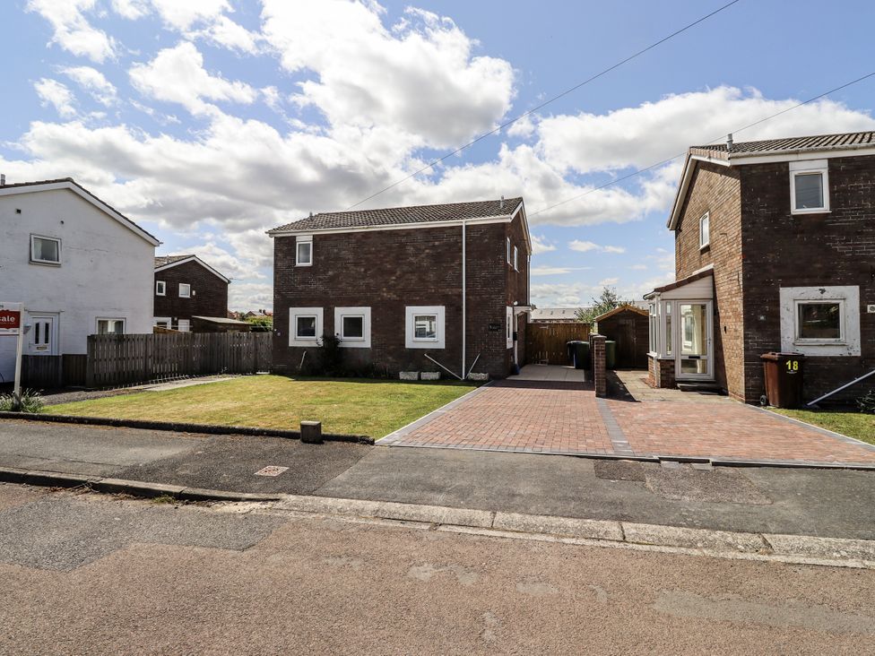 A view of two houses and a lawn at Seahorse Cottage in Chathill