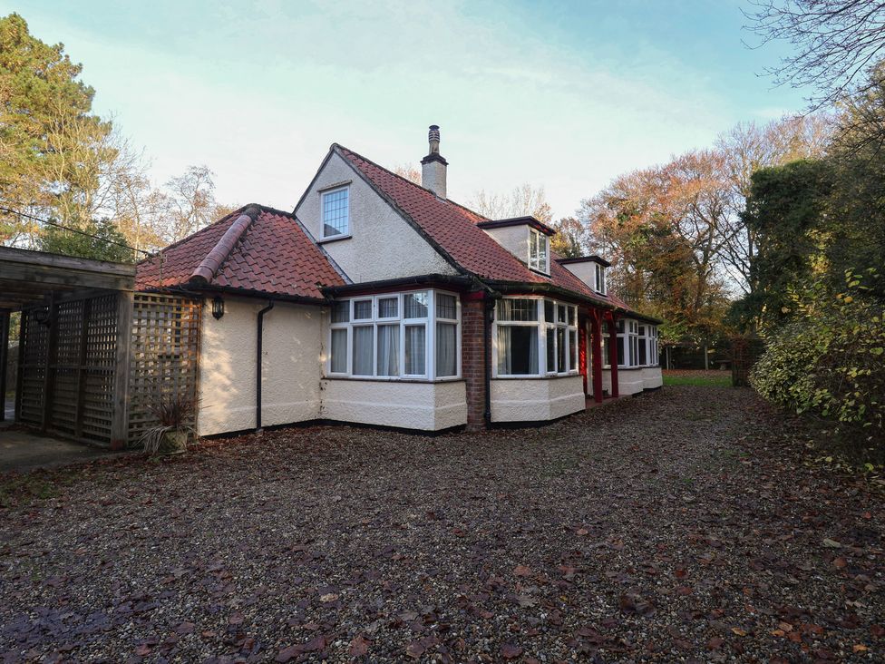 An exterior view of a house with gravel driveway and trees at The Anchorage in 
