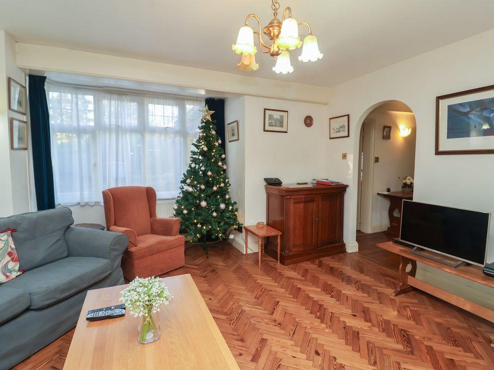 A living room with a Christmas tree and a television at The Anchorage