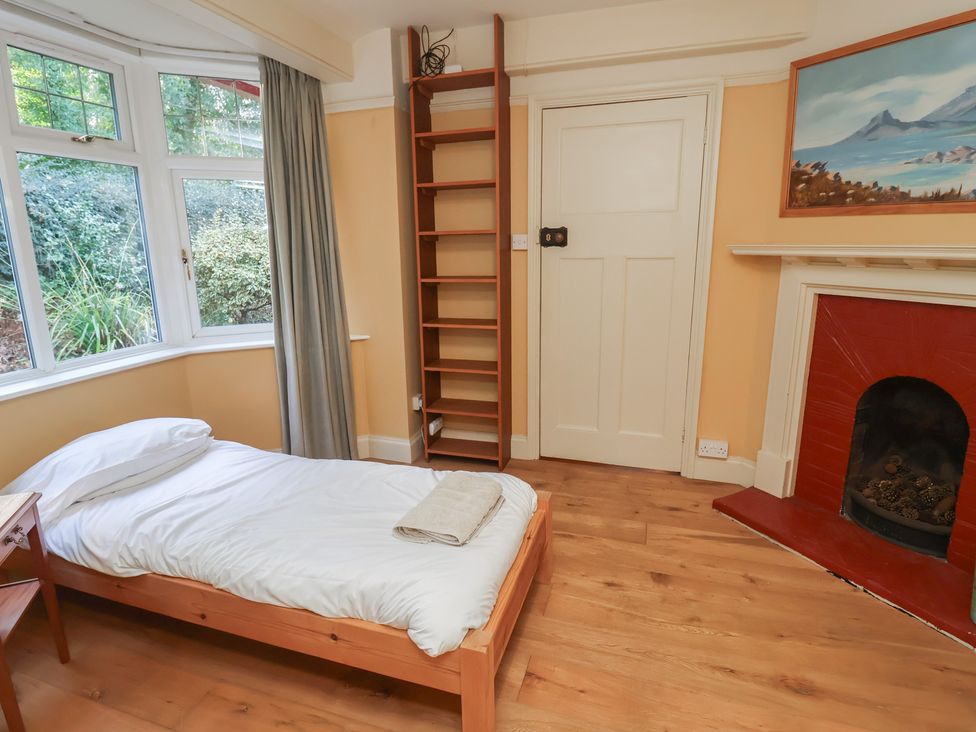 A bedroom with a bed and bookshelf at The Anchorage