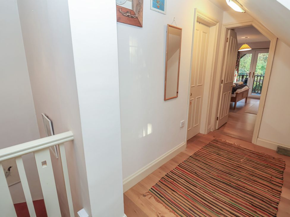 A hallway with a staircase and a mirror at The Anchorage