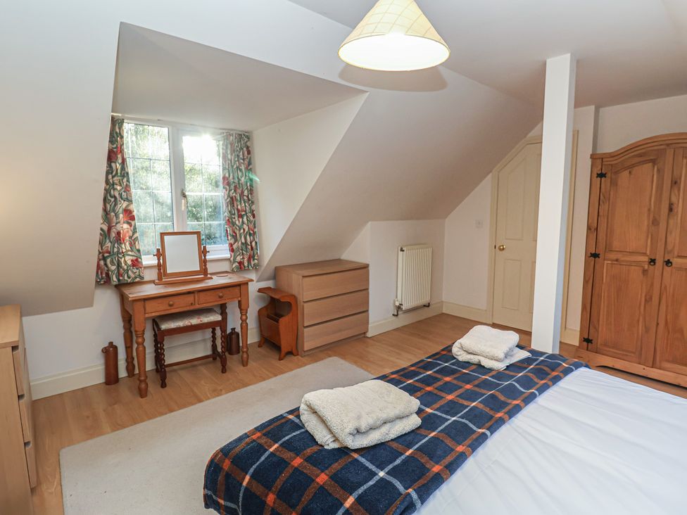 A bedroom with a bed, dresser, and wardrobe at The Anchorage