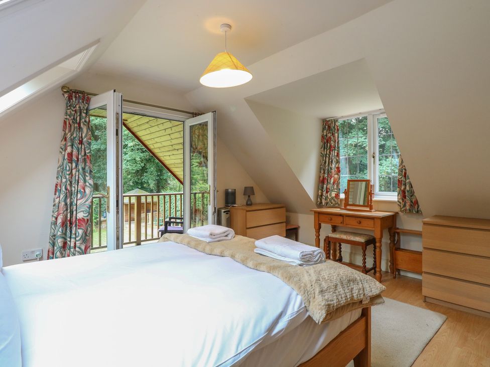 A bedroom with a bed and a dresser at The Anchorage Hoveton & Wroxham