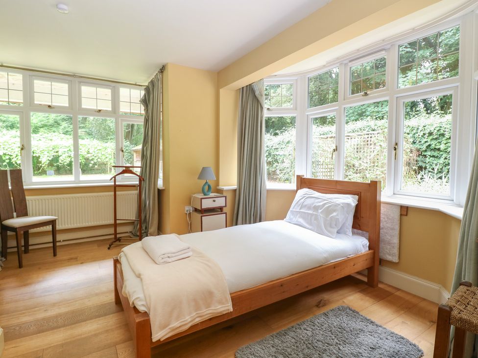 A bedroom with a single bed and windows at The Anchorage in Hoveton & Wroxham