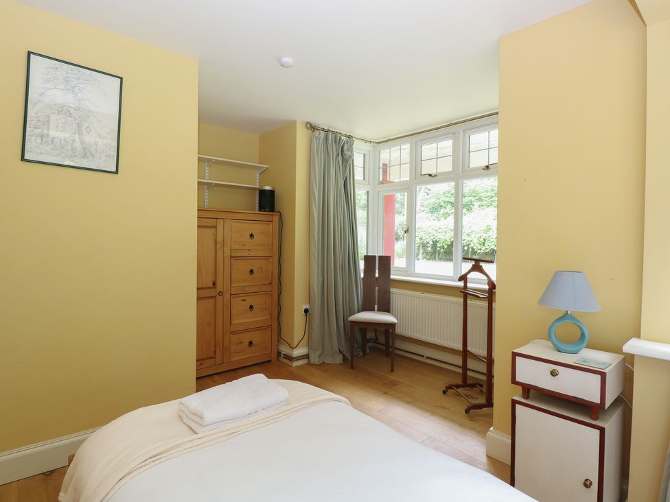 A bedroom with a bed and wardrobe at The Anchorage in Hoveton & Wroxham