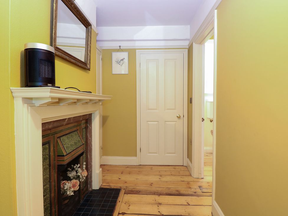 A hallway with a mirror and heater at The Anchorage in Hoveton & Wroxham
