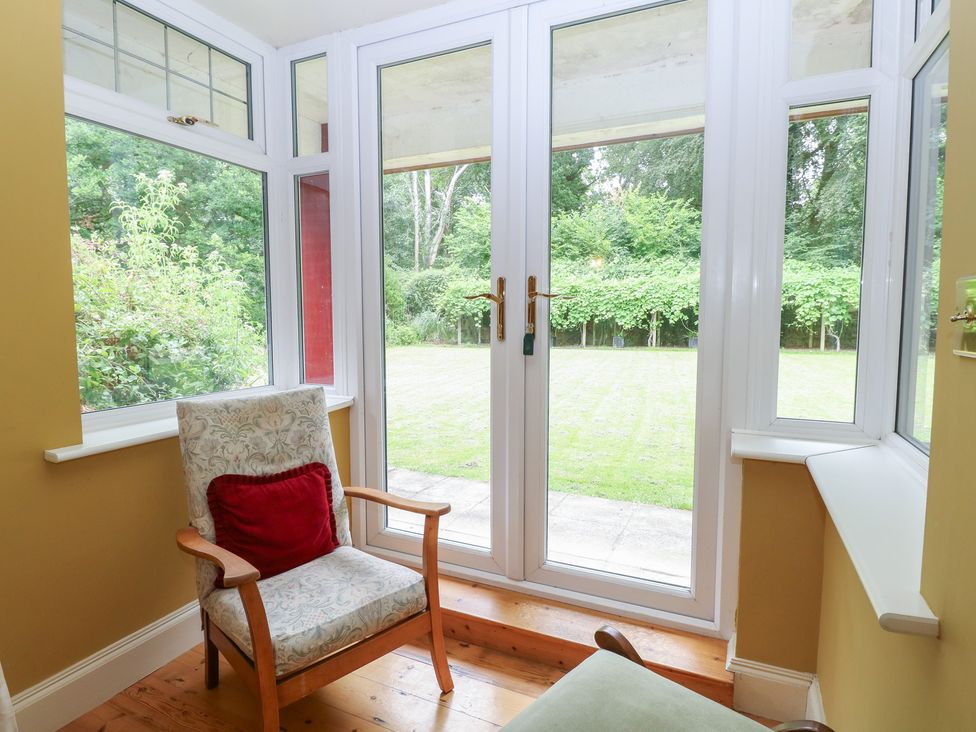 A conservatory with a view of the garden at The Anchorage in Hoveton & Wroxham