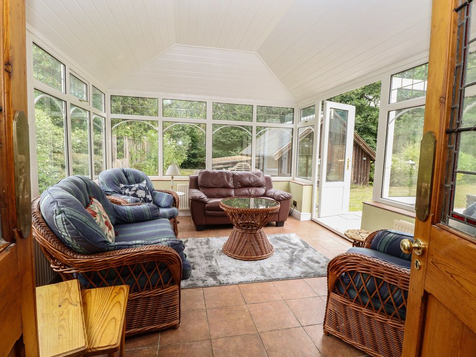 A conservatory with seating and glass walls at The Anchorage in Hoveton & Wroxham