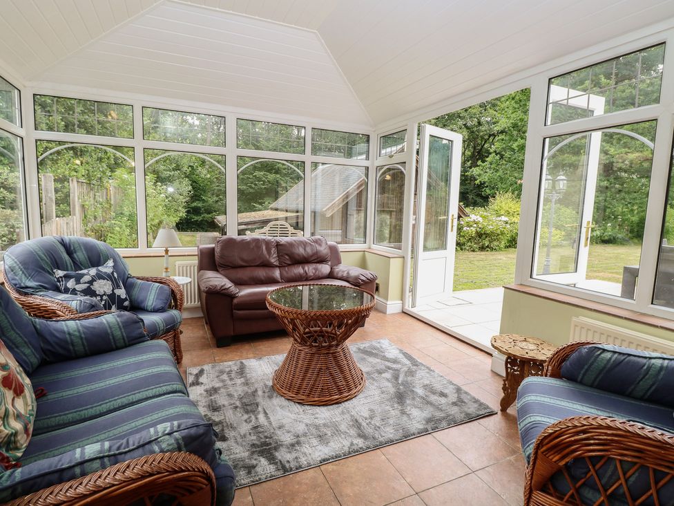 A conservatory with seating and a coffee table at The Anchorage in Hoveton & Wroxham