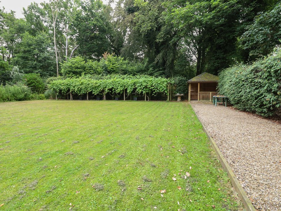 A garden with grass and a gazebo at The Anchorage in Hoveton & Wroxham