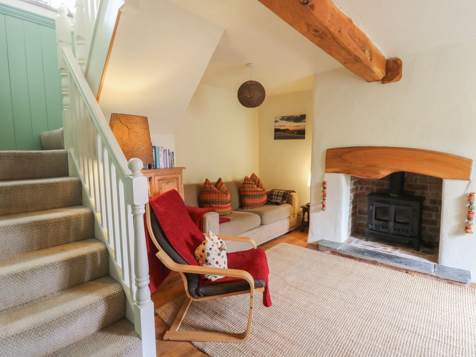 A living room with a staircase and a fireplace at St John's House, Newport, Pembrokeshire