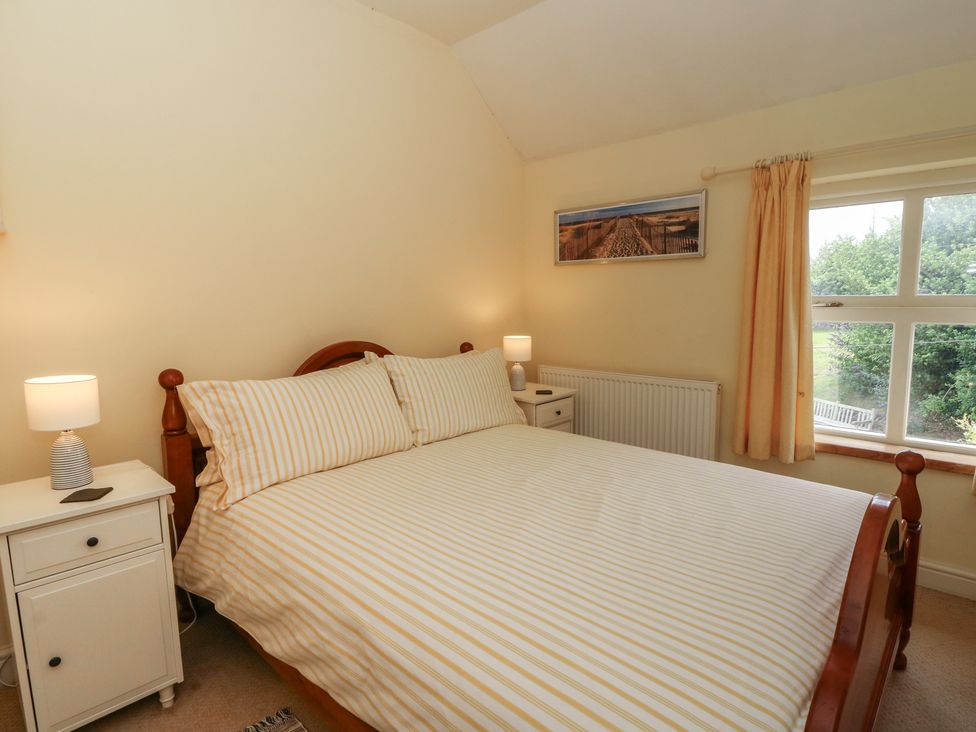 A bedroom with a bed and nightstand at St John's House, Newport, Pembrokeshire