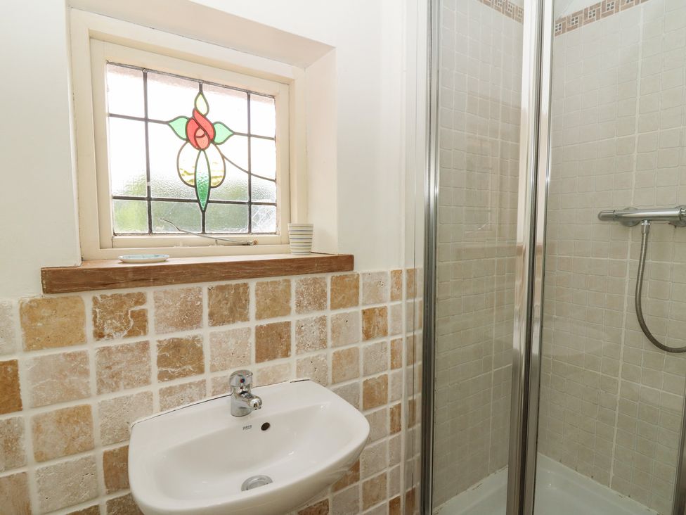 A bathroom featuring a shower and a washbasin at St John's House, Newport, Pembrokeshire