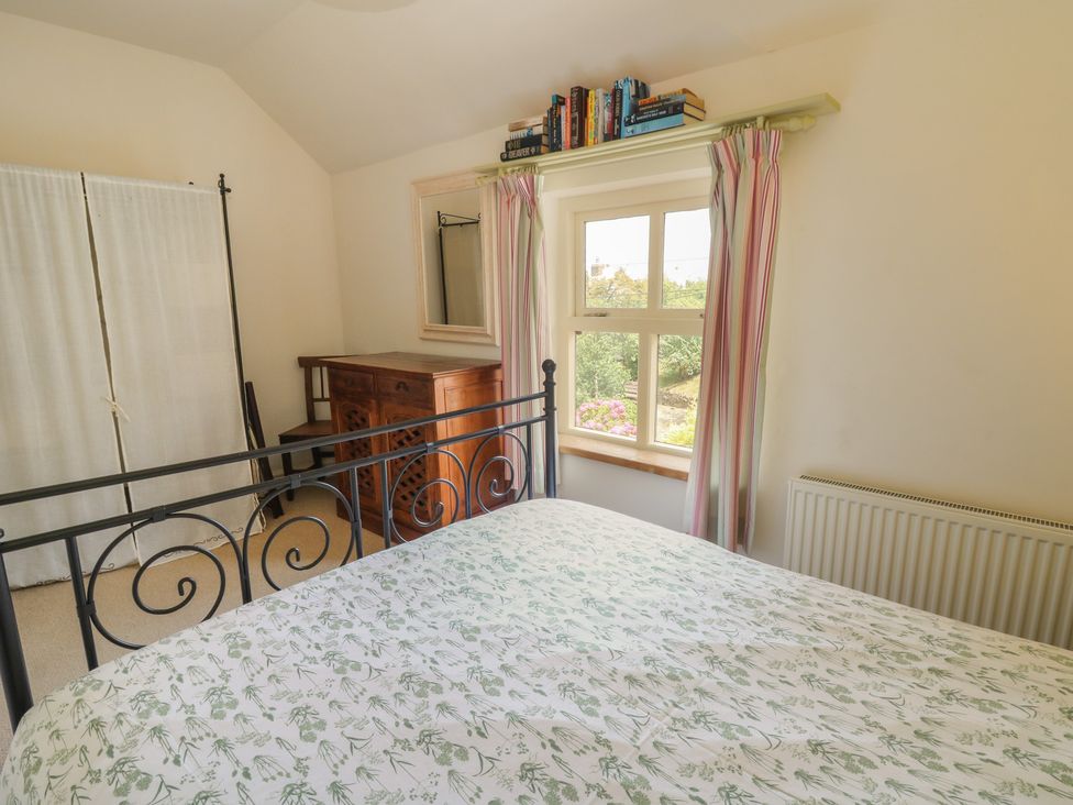 A bedroom with a bed and a dressing table at St John's House in Newport, Pembrokeshire