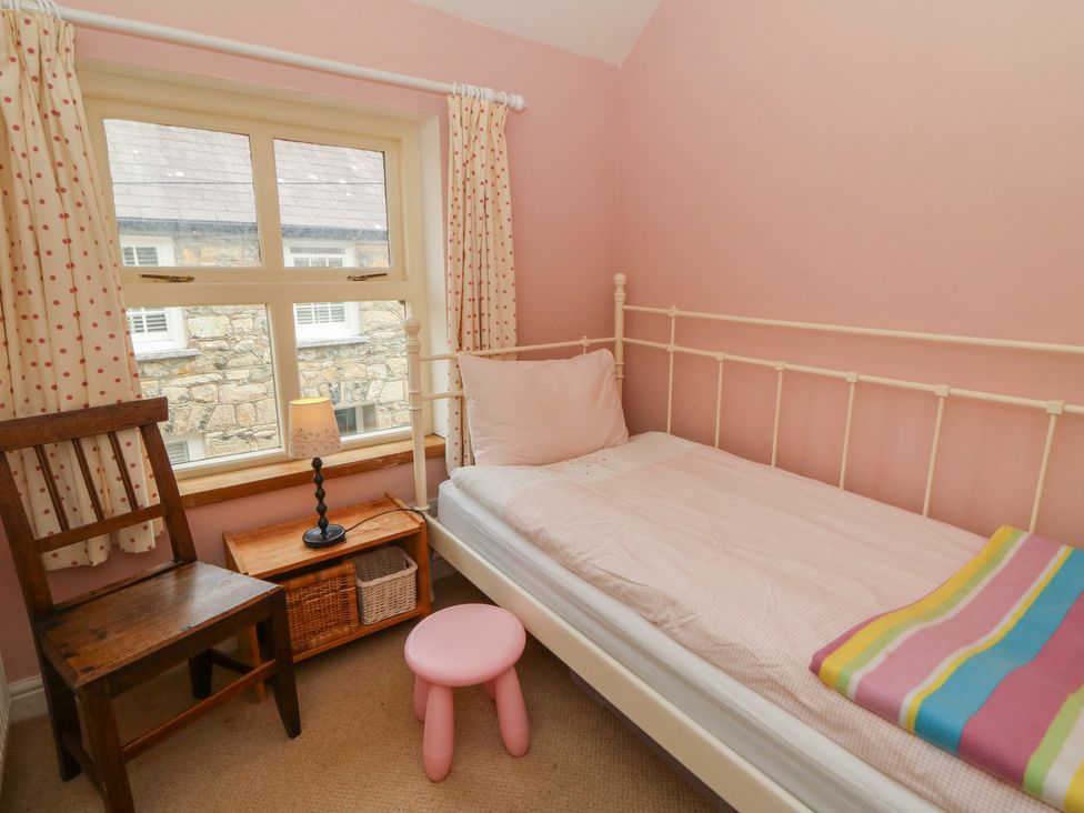 A bedroom with a bed and chair at St John's House in Newport, Pembrokeshire
