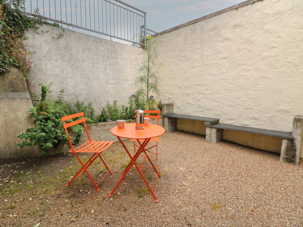 A patio area with orange chairs and table at St John's House in Newport, Pembrokeshire