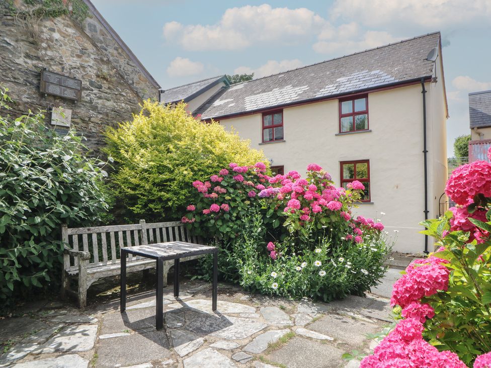 A garden with a bench and flowers at St John's House in Newport, Pembrokeshire