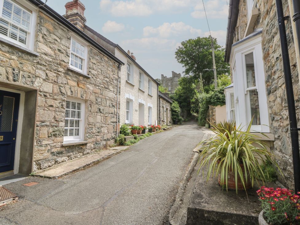 An outdoor view of a street with stone buildings and flower pots at St John's House in Newport, Pembrokeshire